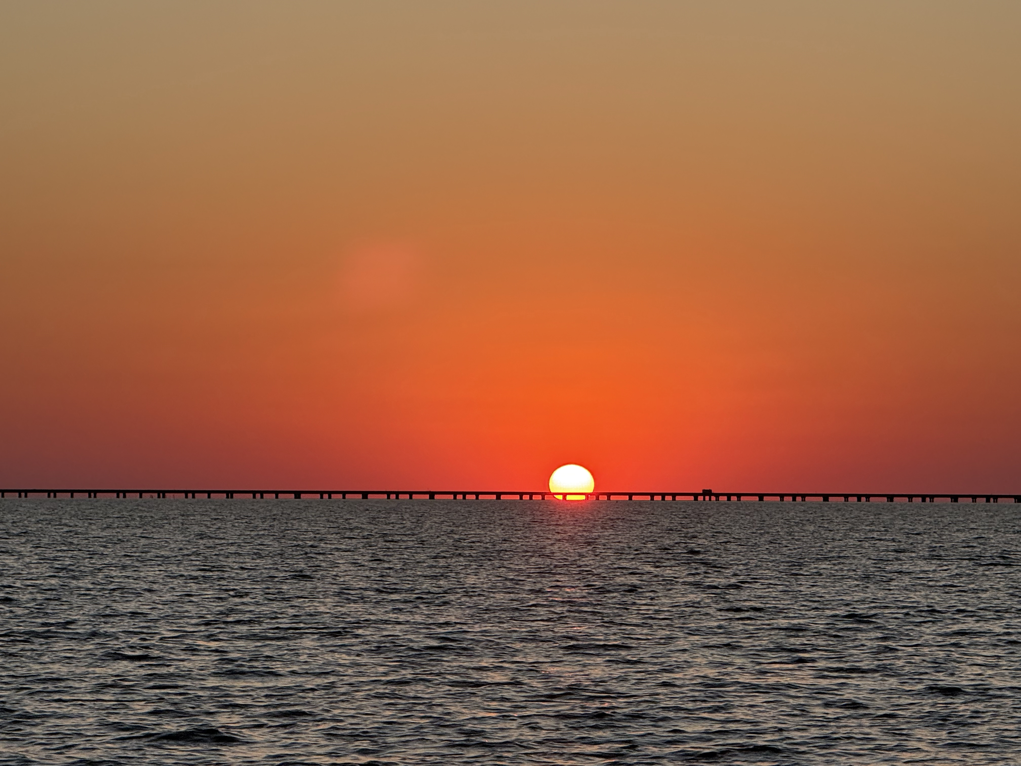 The sun setting over Lake Pontchartrain behind the Causeway bridge